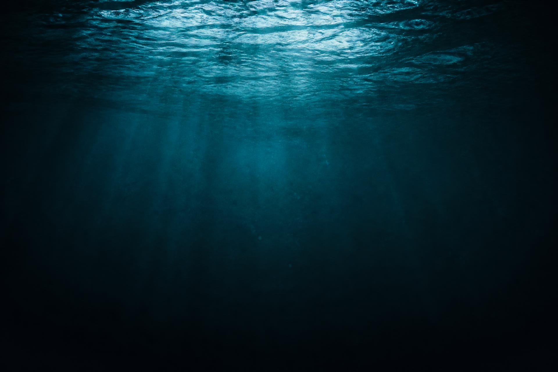 Dark underwater water surface with light rays